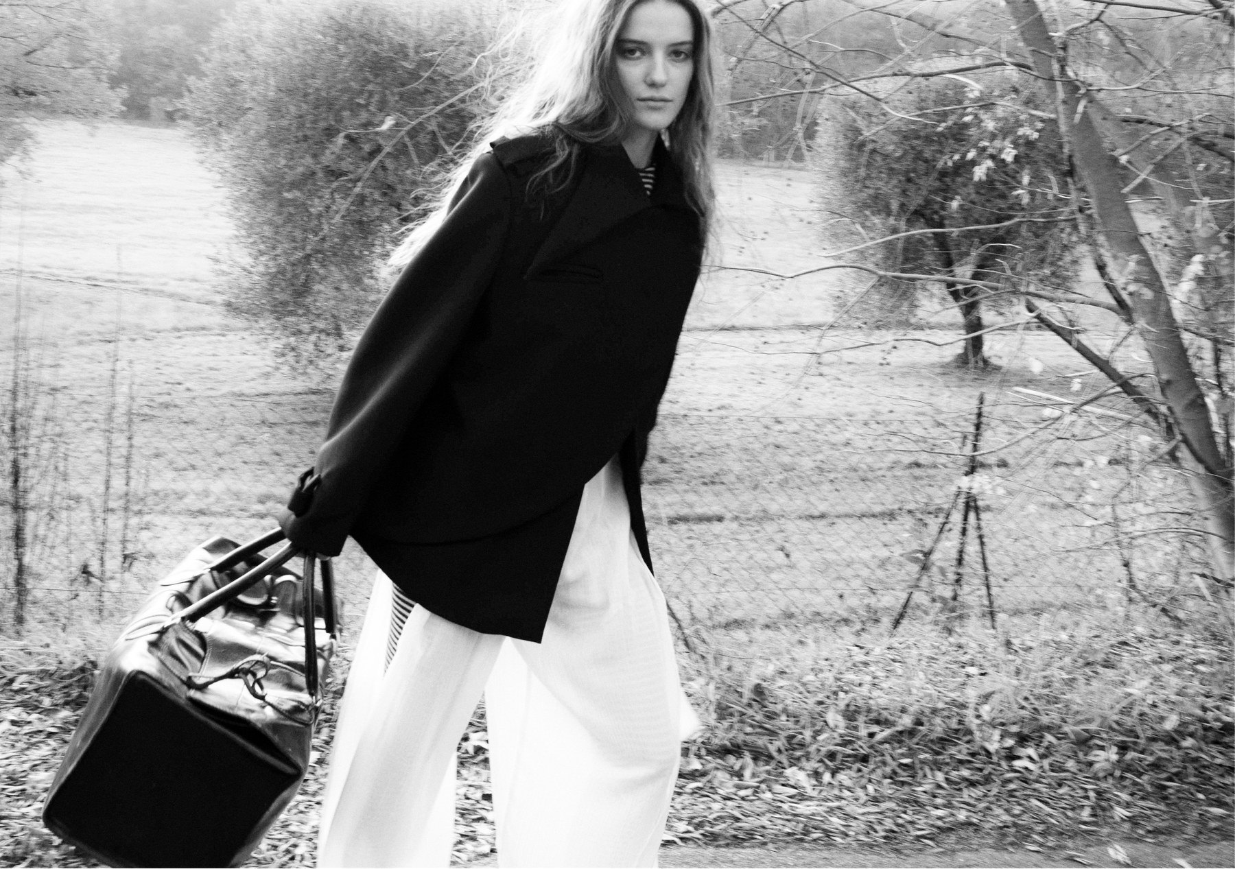 Walking with the miser purse bag, black jacket and white trousers